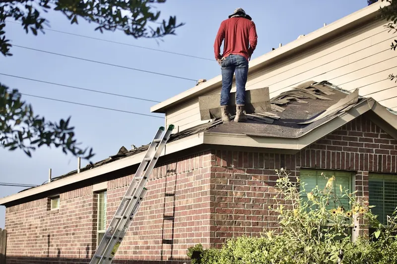 Professional roofer working on a residential roof in Little Blue